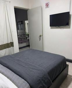 ein Schlafzimmer mit Bett und Flachbildfernseher in der Unterkunft Hotel Descanso in Santa Ana Chiautempan