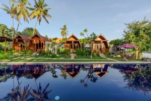 a resort with a pool and palm trees at Arta Bali Glamping in Tianyar