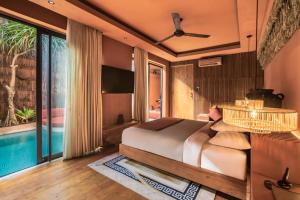 a bedroom with a bed and a large window at Sana Vie Villa Seminyak by Ini Vie Hospitality in Seminyak