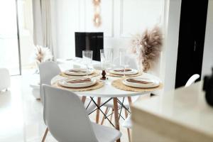 une table blanche avec des chaises blanches et une salle à manger blanche dans l'établissement Tropical Oasis-Luxury Apartment, à Trevallyn
