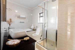 une salle de bains avec toilettes et douche en verre dans l'établissement Tropical Oasis-Luxury Apartment, à Trevallyn 7 autres photos