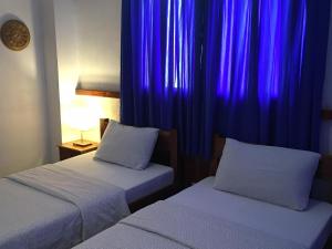 two beds in a room with purple curtains at Pahiluna Guesthouse in Panglao Island +82 photos