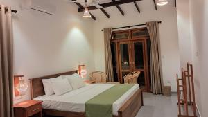 a bedroom with a bed and a table and a window at The Clouds Ahangama in Ahangama