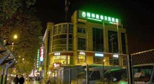 a building with a sign on top of it at night at GreenTree Inn Shanghai Hongqiao Hub Convention Center Jinghua Road Shell Hotel in Fangjiayao