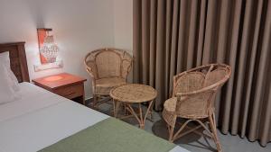 a hotel room with two chairs and a bed at The Clouds Ahangama in Ahangama +4 photos