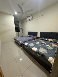 Un dormitorio con dos camas y un ventilador de techo. en 96 HomeStay Sungai Besar, en Sungai Besar