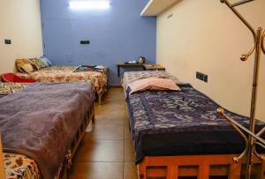 a room with three beds and a table at AnanthaSayanam Homestay Near Sri Padmanabha Swamy Temple in Trivandrum +12 photos