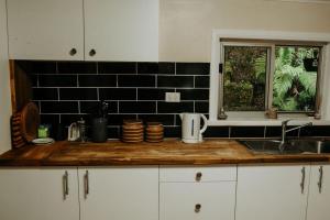 Una encimera de cocina con un fregadero y una ventana. en Little Yellow Cottage Queenstown, en Queenstown 28 fotos más