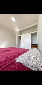 a bedroom with a bed with a purple bedspread at Budget-friendly room near Sunshine Station to CBD in Sunshine