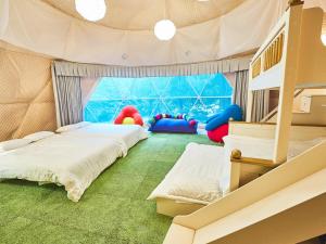 two beds in a room with a tent at リバーサイドグランピングNuts in Higashiomi