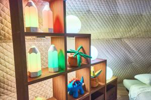 a wooden book shelf with toys and a plant at リバーサイドグランピングNuts in Higashiomi