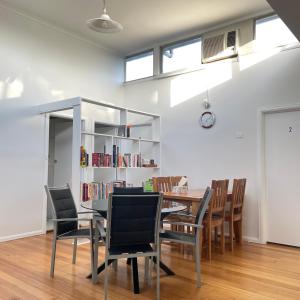 a dining room with a table and chairs and a book shelf at Budget-friendly room near Sunshine Station to CBD in Sunshine +17 photos