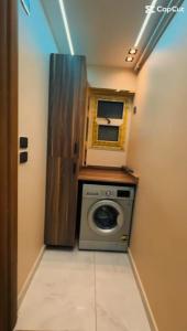 una lavadora y secadora en una habitación pequeña en ميدان لبنان المهندسين برج ابو الكرامات, en El Cairo 20 fotos más