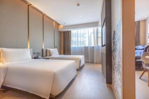Ένα ή περισσότερα κρεβάτια σε δωμάτιο στο Atour Hotel (Wuhan Qingshan Peace Park)