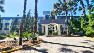 a building with palm trees in front of it at Privilege Apart hotel Mountain Village in Canela