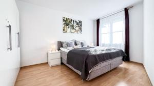 a bedroom with a bed and a large window at Ferienwohnung in der Stadt mit kostenfreier Tiefgarage bis 1,50m Fahrzeughöhe - 2 Doppelbetten, Küche, Bad in Leipzig