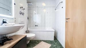 a white bathroom with a sink and a toilet at Ferienwohnung in der Stadt mit kostenfreier Tiefgarage bis 1,50m Fahrzeughöhe - 2 Doppelbetten, Küche, Bad in Leipzig