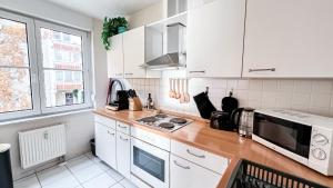 a kitchen with white cabinets and a counter top at Ferienwohnung in der Stadt mit kostenfreier Tiefgarage bis 1,50m Fahrzeughöhe - 2 Doppelbetten, Küche, Bad in Leipzig