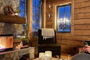 Una sala de estar con una silla y una chimenea. en Winter Haven Idre - Happy Rentals, en Idre