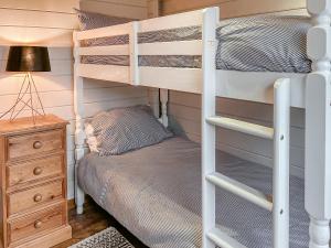 een slaapkamer met een stapelbed en een nachtkastje met een lamp bij The Lodge - Uk50721 in Aldbrough +2 foto's