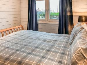 een bed in een kamer met een raam bij The Lodge - Uk50721 in Aldbrough
