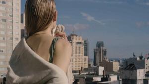 a woman standing on top of a building looking at a city at The Huntington Hotel in San Francisco