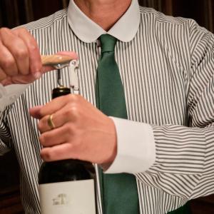 a man in a shirt and tie holding a bottle of wine at The Huntington Hotel in San Francisco +6 photos