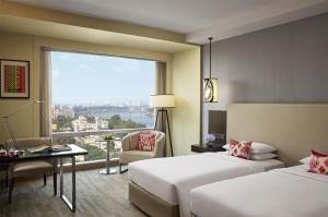 a hotel room with two beds and a large window at Hyatt Regency Ahmedabad in Ahmedabad +55 photos