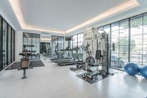 a gym with treadmills and machines in a building at Marigold Sukhumvit - Free Shuttle to BTS Bearing Station in Bangkok