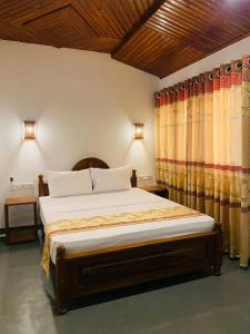 a bedroom with a large bed and curtains at Mountain Peak Homestay Hiriketiya in Dickwella
