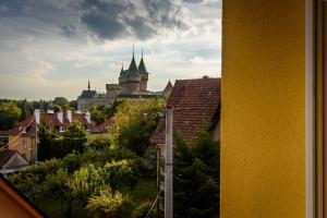 a view of a castle from a city with roofs at Apartmany Hujer in Bojnice