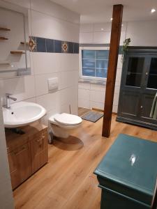 Un baño con un inodoro blanco y un lavabo. en Bei GRETA 33, en Marl