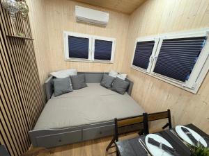 a small bed in a room with two windows at KE-Tiny Haus Paulchen in Oerlenbach