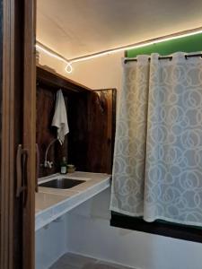 a bathroom with a sink and a shower curtain at Charity Pension House in San Vicente +71 photos