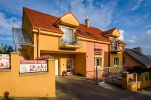 una casa amarilla con techo rojo en Apartmany Hujer, en Bojnice