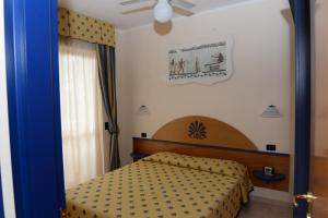 a bedroom with a bed with a yellow bedspread at Casa Vacanze Oasi Felicita in Nova Siri Marina