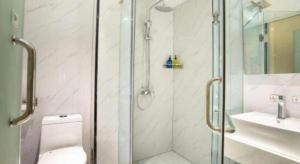 a bathroom with a shower and a toilet and a sink at 7 Days Inn Luoyang Railway Station Wangcheng Avenue in Luoyang