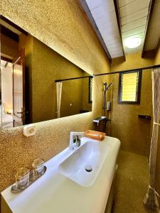 a bathroom with a white sink and a mirror at Holiday Beach Hotel in Nosy Be +66 photos