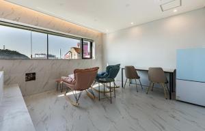 群山市Gunsan LAONHAJE的配有椅子和桌子的房间以及窗户