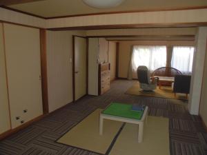 a living room with a table and a couch at プチキャンプ場おちぼの郷 in Furano