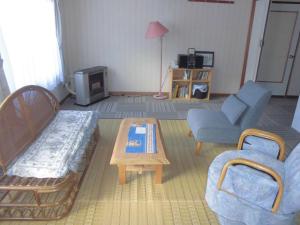 a living room with a couch and a coffee table at プチキャンプ場おちぼの郷 in Furano