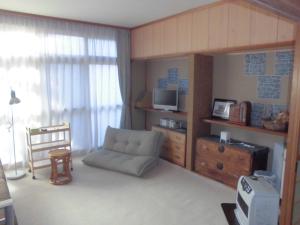 a small living room with a couch and a dresser at プチキャンプ場おちぼの郷 in Furano