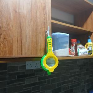a pair of scissors hanging from a kitchen cabinet at Mikes apartment in Mombasa