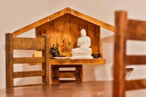 a small wooden house with a statue on a table at White Rose Holiday Resort in Anuradhapura