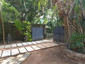 a garden with a fence and a wooden walkway at White Rose Holiday Resort in Anuradhapura