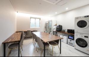 群山市Gunsan LAONHAJE的厨房配有桌椅、洗衣机和烘干机