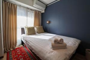 a bedroom with a bed with a towel on it at Al Di La 四谷 in Tokyo