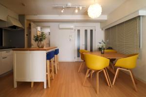 a kitchen with a table and yellow chairs at Al Di La 四谷 in Tokyo +25 photos
