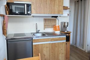 Una pequeña cocina con fregadero y microondas. en Studio 1 chambre pied des pistes 24 m2, en Risoul