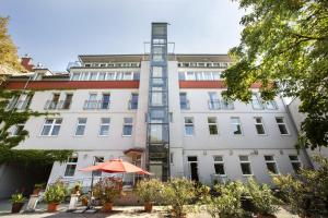 einen orangenen Regenschirm vor einem weißen Gebäude in der Unterkunft Hahn Hotel Vienna in Wien